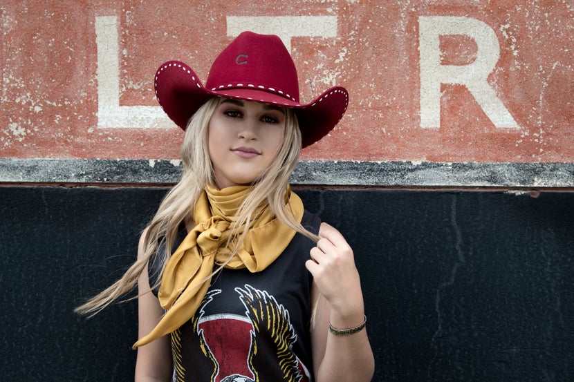 Girl wearing red Charlie1Horse cowboy hat and mustard colored wild rag